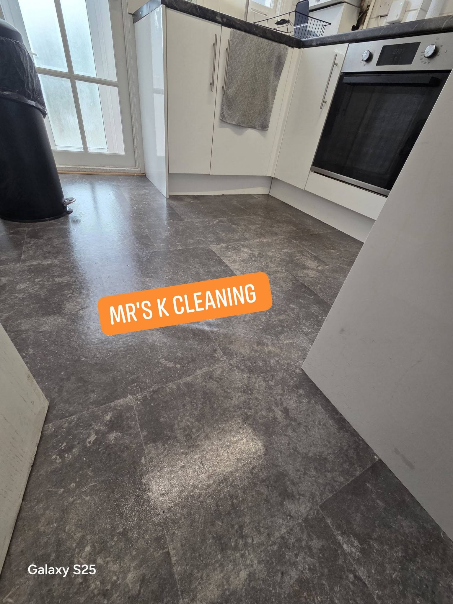 Sparkling grey tiled kitchen floor after a deep clean