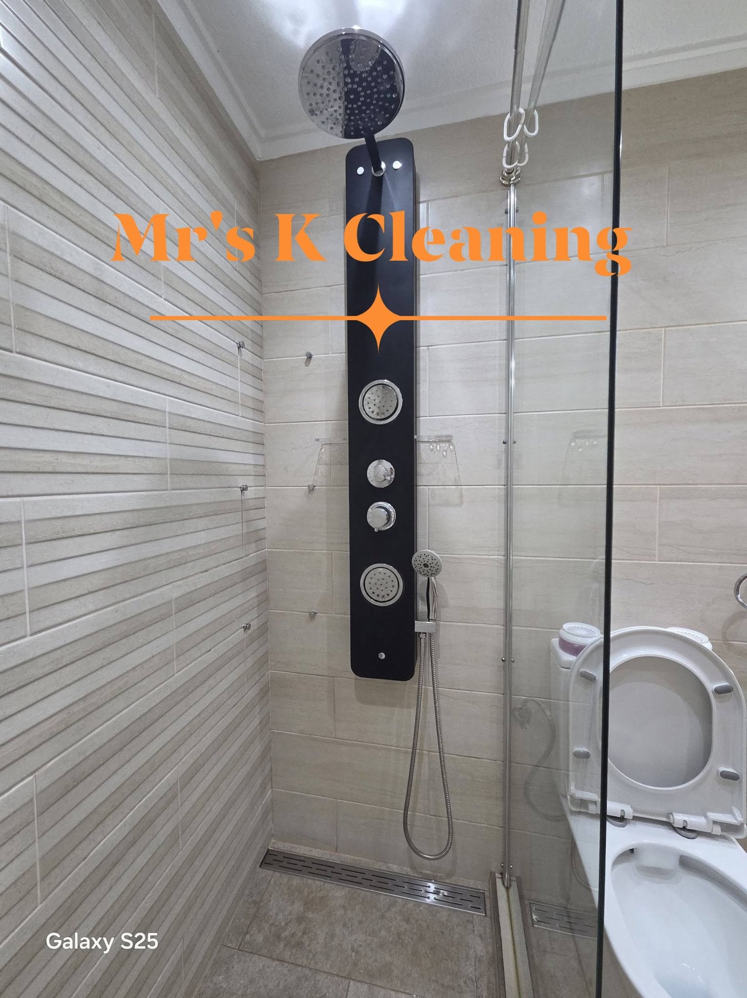 Clean tiled shower enclosure with black shower panel